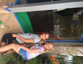 Zoe and Emily painting the windows of Sanctuary Salon & Spa.