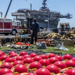 Sailors and federal San Diego firefighters fight fire aboard USS Bonhomme Richard