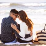 couple sitting on beach heads together