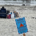 sewage beach water warning sign