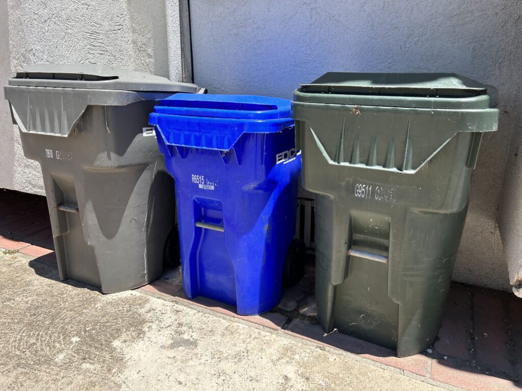 Single Big Green Plastic Dumpster Full Of Trash In A Dirty Yard