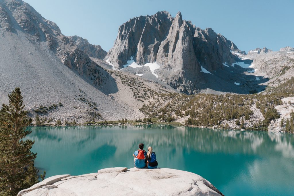 Couple sitting on a rock overlooking Big Pine Lakes.