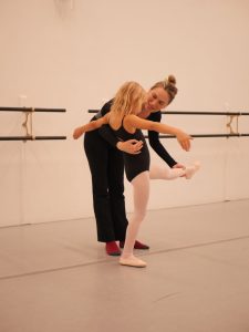 Dance teacher instructs a young child