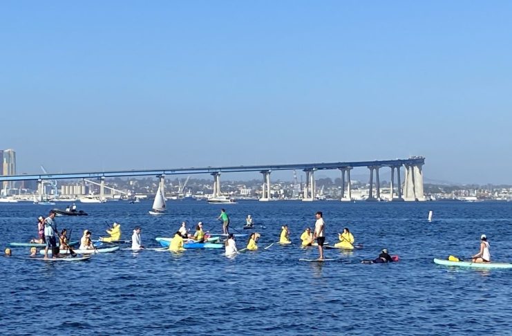 SD Climate week paddle out in Glorietta Bay with bridge in background.